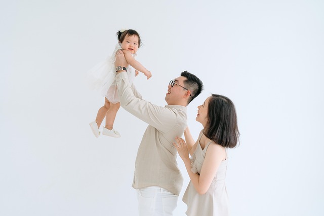 아빠가 아이를 바라보며 웃고, 옆에서 그 모습을 엄마가 흐믓해 하면서 바라보고 잇는 사진